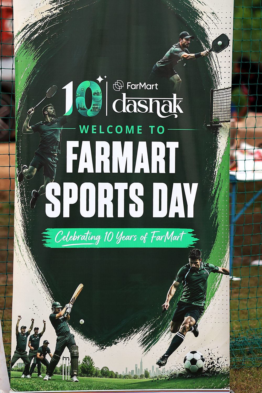 A roll-up banner reading 'Welcome to FarMart Sports Day, celebrating 10 years of FarMart', under the 10 FarMart dashak lockup, with cricket, football, badminton and pickleball players on a green brushstroke background.